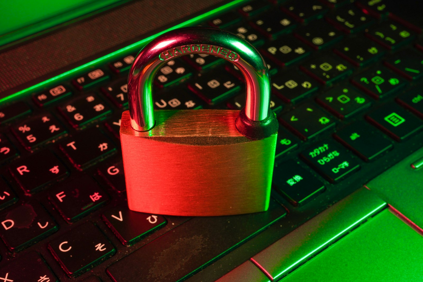 Hardened padlock resting on a backlit laptop keyboard
