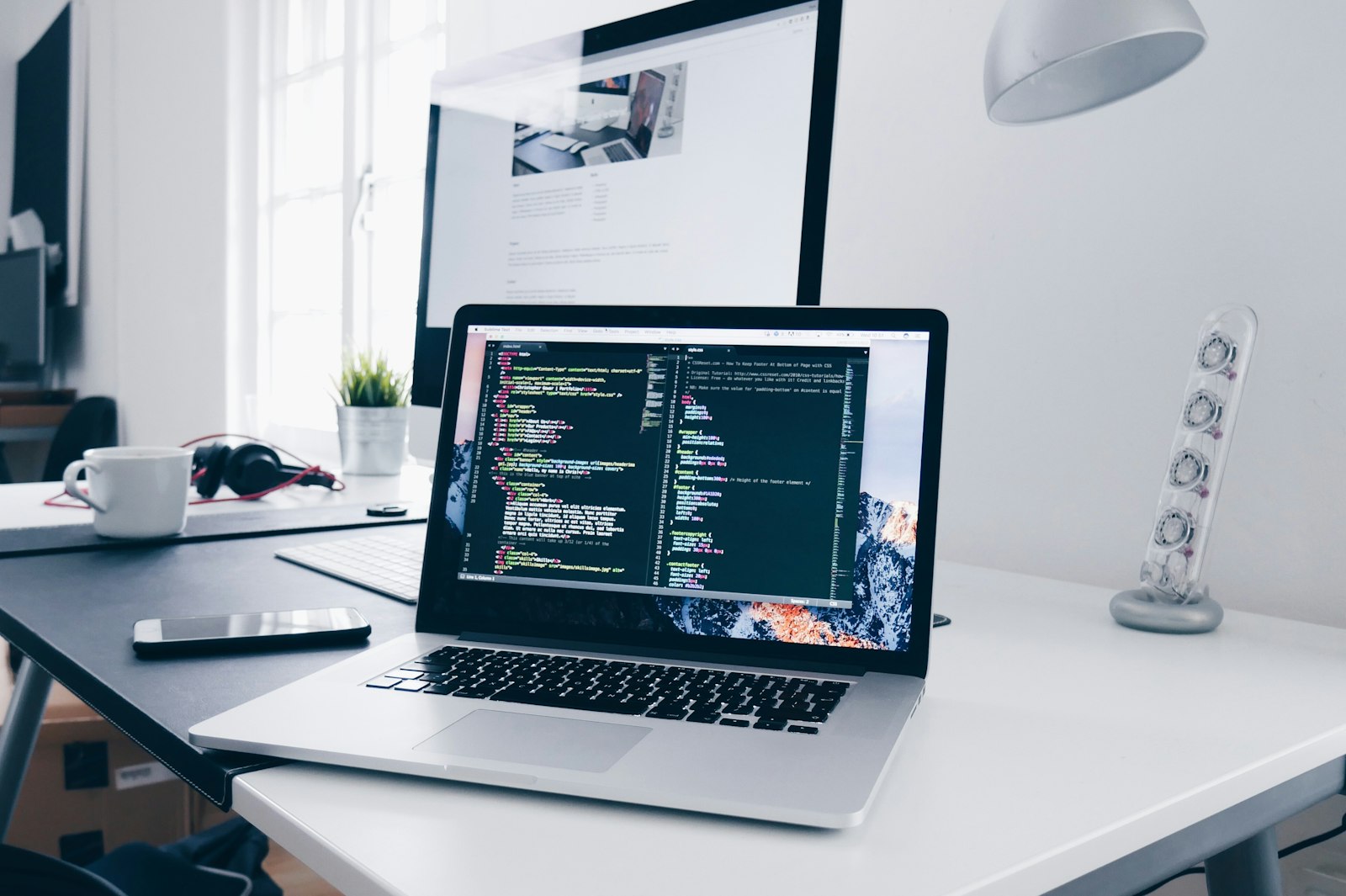 Laptop on a desk showing an open code editor