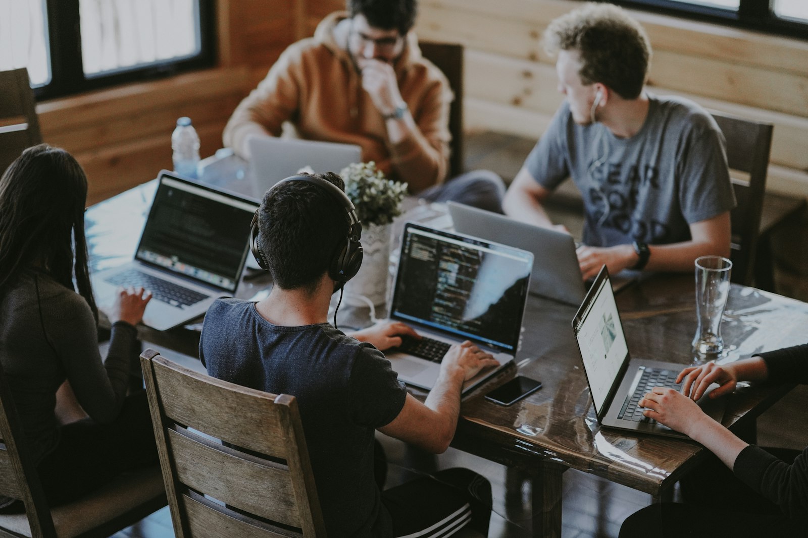 Engineers working together on laptops around a shared table
