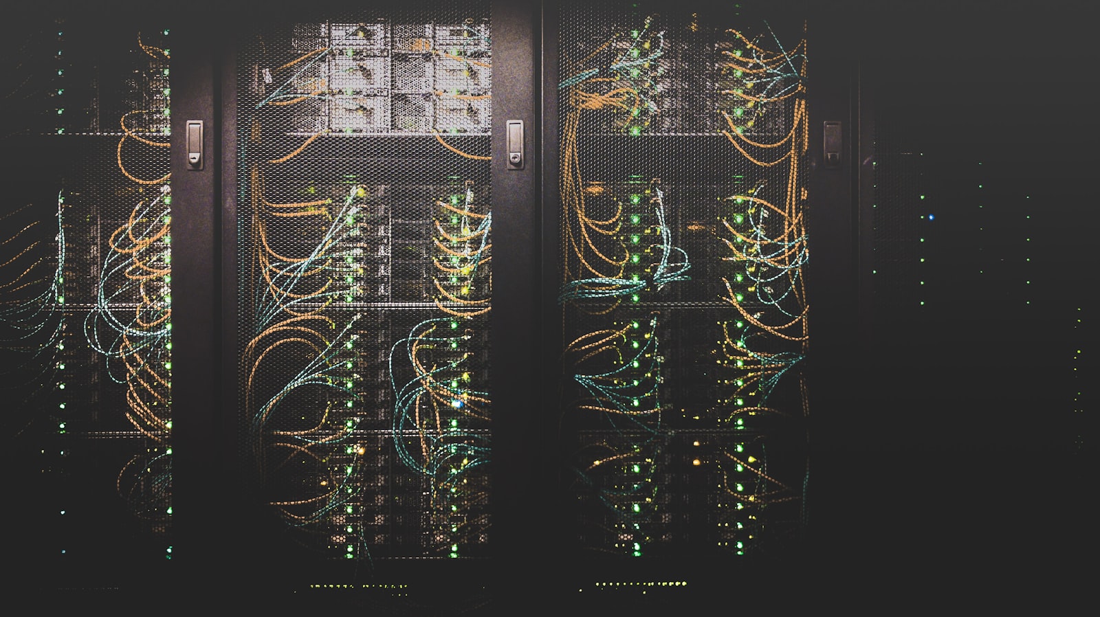 Server racks in a data center with orange and blue network cabling