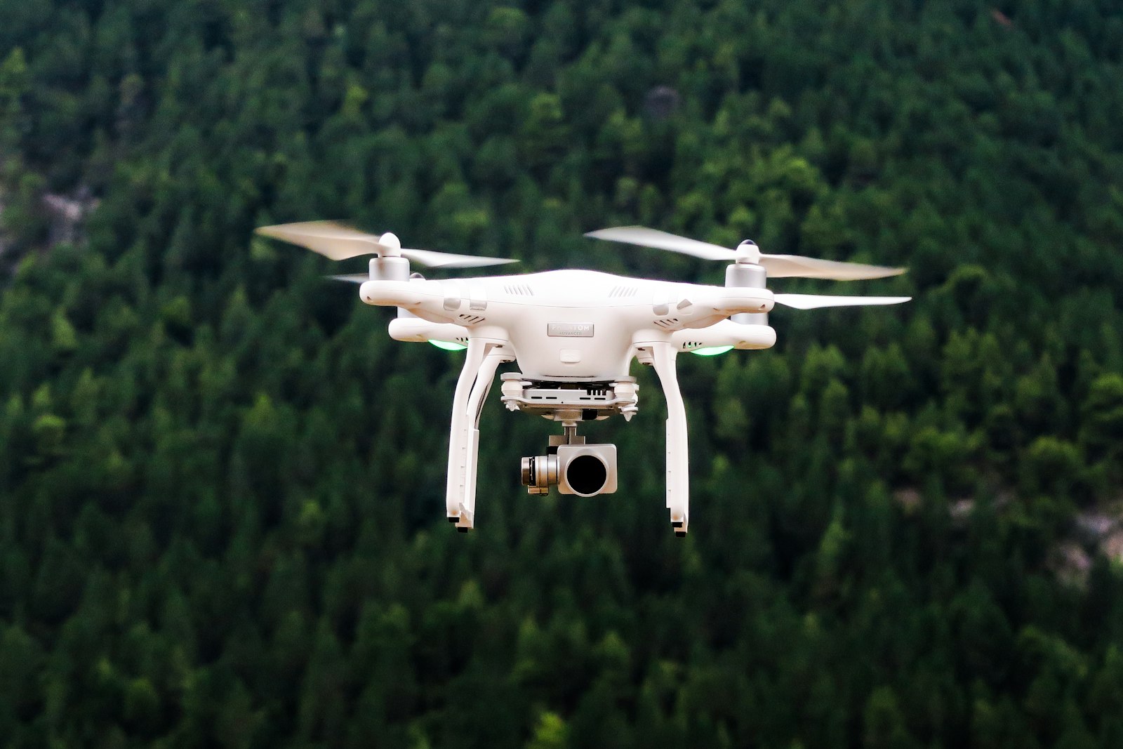Camera drone hovering above a forest